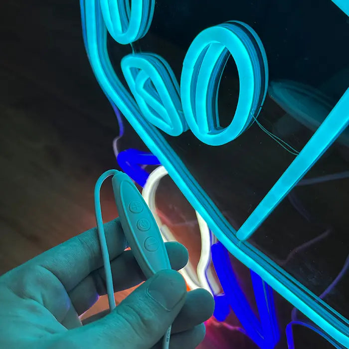 Pokémon Eiscue Neon LED Sign with the inline dimmer in hand in front of the glowing neon lines