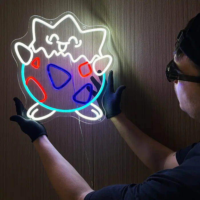 Pokémon Togepi Neon LED Sign aligned on the wall with black gloves