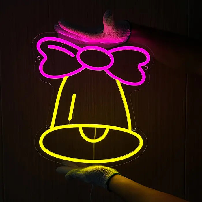 Little Bell Neon LED Sign held against a dark wall, the contours made of neon tubing clearly visible