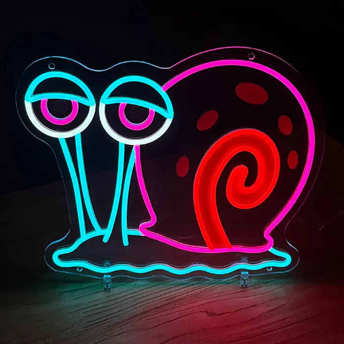 Gary the Snail Neon LED Sign standing on a wooden floor, the complete contour glowing