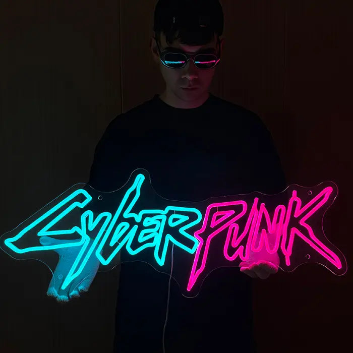 CYBERPUNK Neon LED Sign held in front of the body, both parts of the lettering glowing evenly