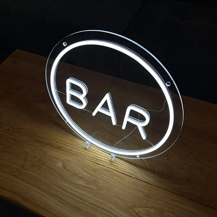 BAR Neon LED Sign at an angle on a wooden table, clear acrylic panel and stands visible