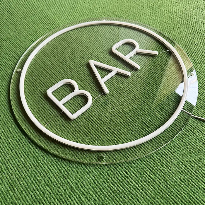 BAR Neon LED Sign switched off on a green surface, ring and letters made of white neon tubing