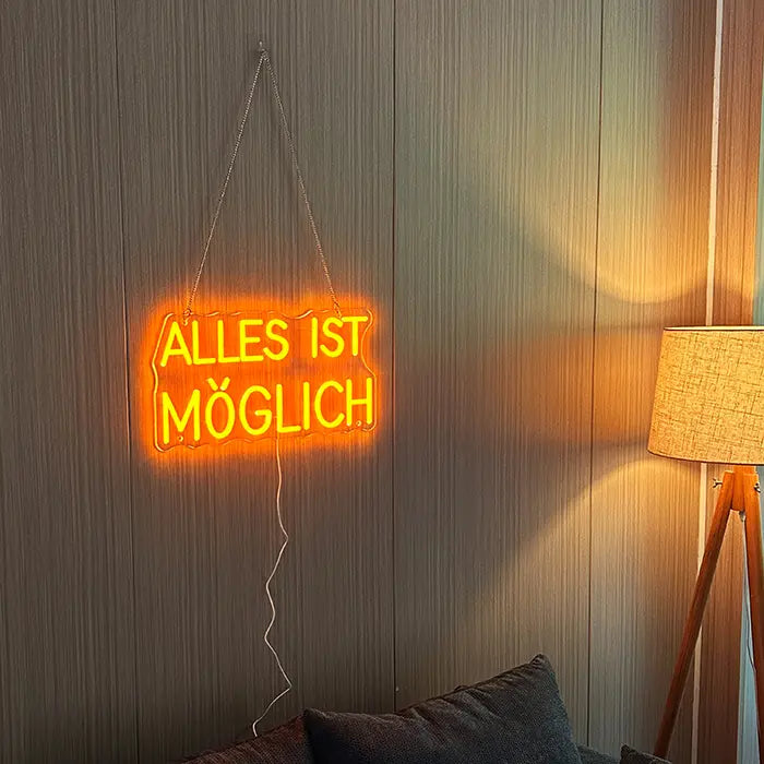 Anything Is Possible Neon LED Sign hung on chains on a wooden wall, next to it a floor lamp