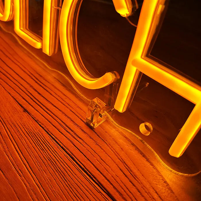 Anything Is Possible Neon LED Sign in detail with a stand on a wooden surface, letters glowing