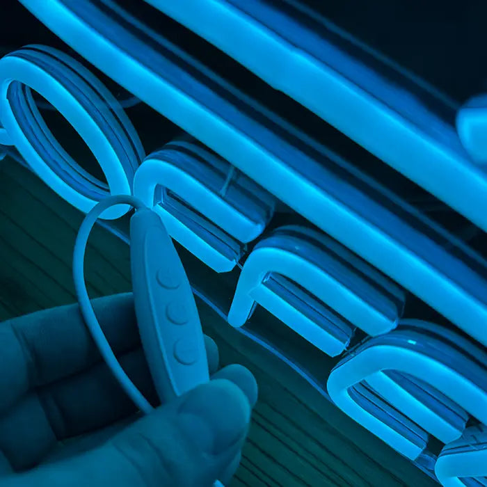 Coffee Cup Neon LED Sign in close-up with the inline dimmer in hand in front of the letters