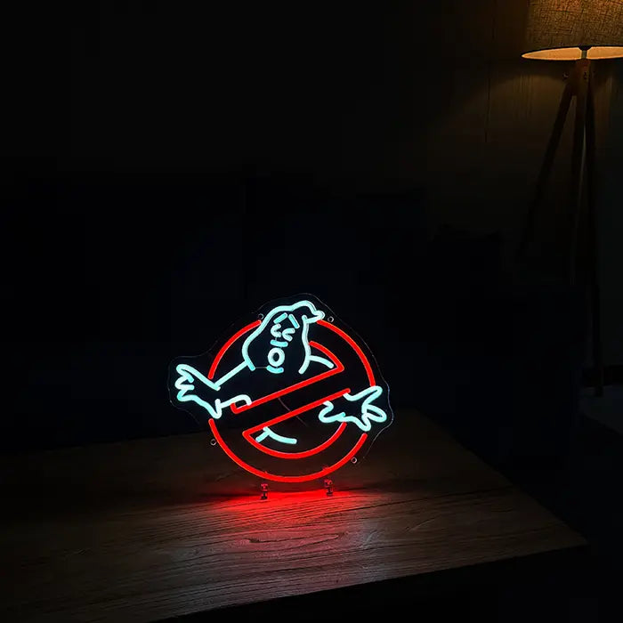 Ghostbusters Logo Neon LED Sign on stands on a wooden table in a dark room