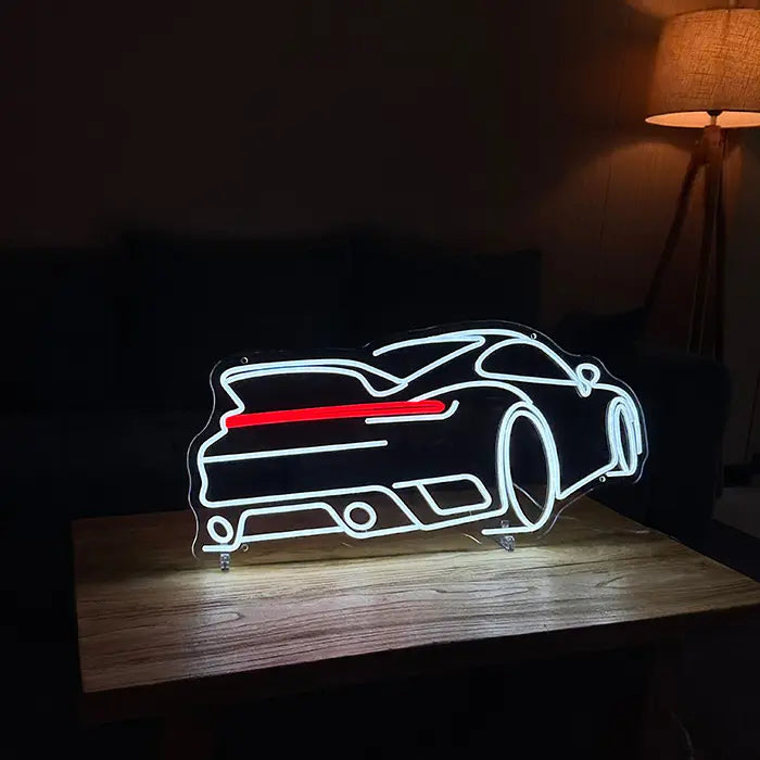 GT Sports Car Neon LED Sign on stands on a wooden table, a floor lamp behind