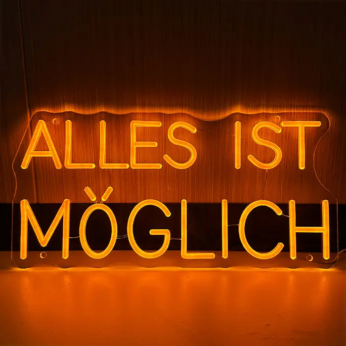 Anything Is Possible Neon LED Sign front view on a dark wooden wall, two-line German lettering in warm orange