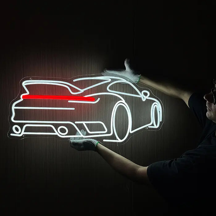 GT Sports Car Neon LED Sign being held against a dark wall with gloves