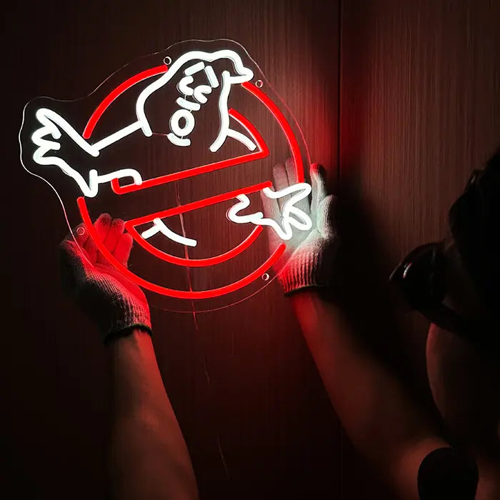 Ghostbusters Logo Neon LED Sign being lined up on the wall, a person in gloves holds it in place