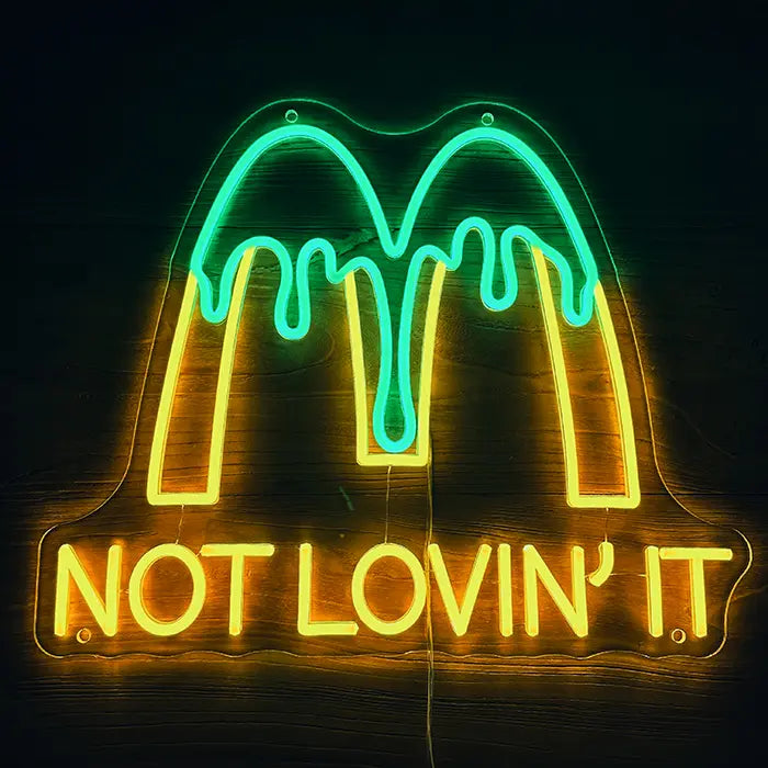 McDonald's Not Lovin' It Neon LED Sign front view on a dark wall, yellow M with green drip effect above the lettering