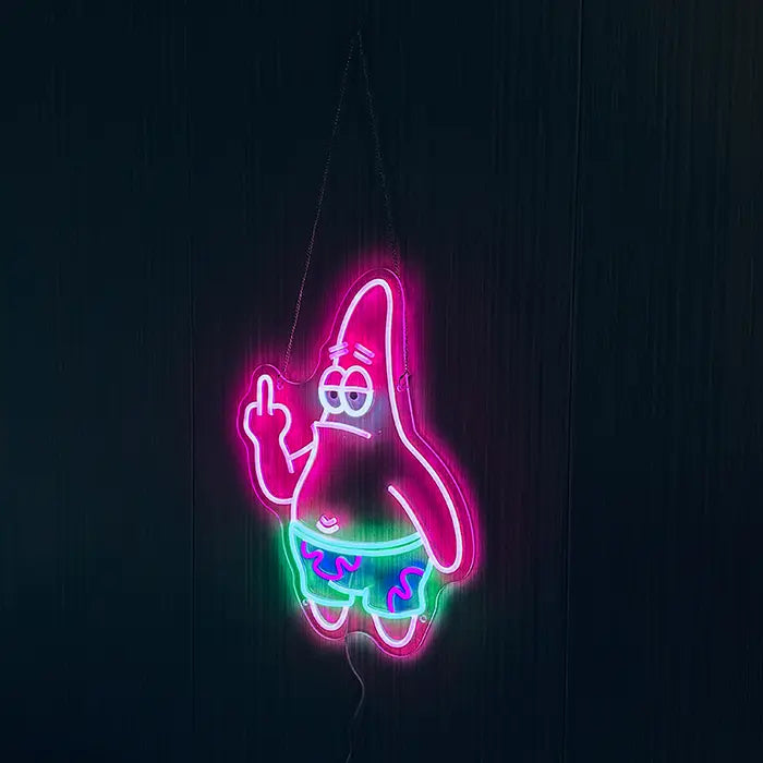 Patrick Middle Finger Neon LED Sign hung on chains in front of a dark wall, pink and green glowing