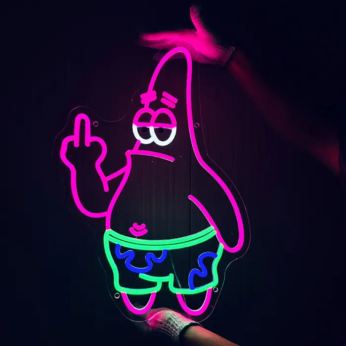 Patrick Middle Finger Neon LED Sign being held against a dark wall with gloves