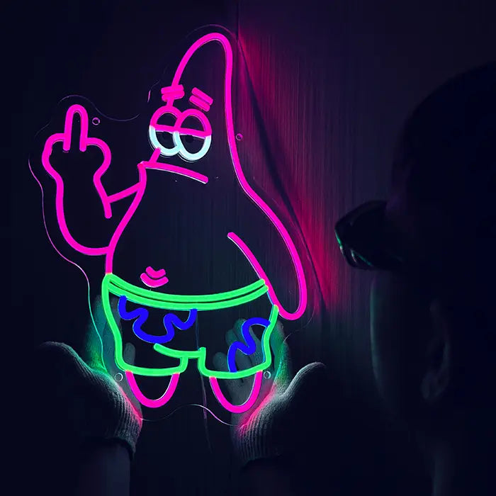 Patrick Middle Finger Neon LED Sign being lined up on the wall, a person holds it from below