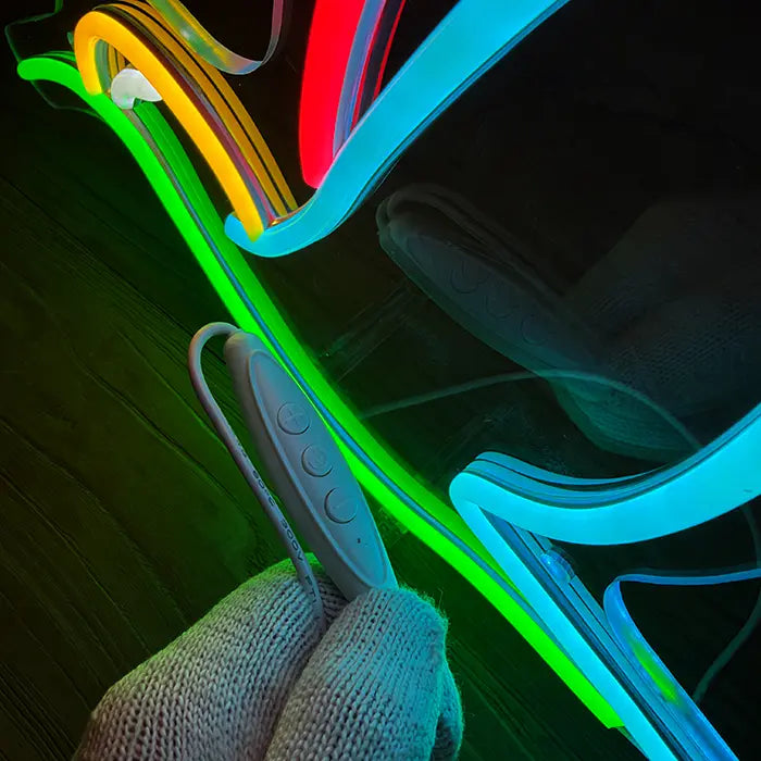 Hummingbird Bird Neon LED Sign in close-up with the inline dimmer in hand in front of the green tube