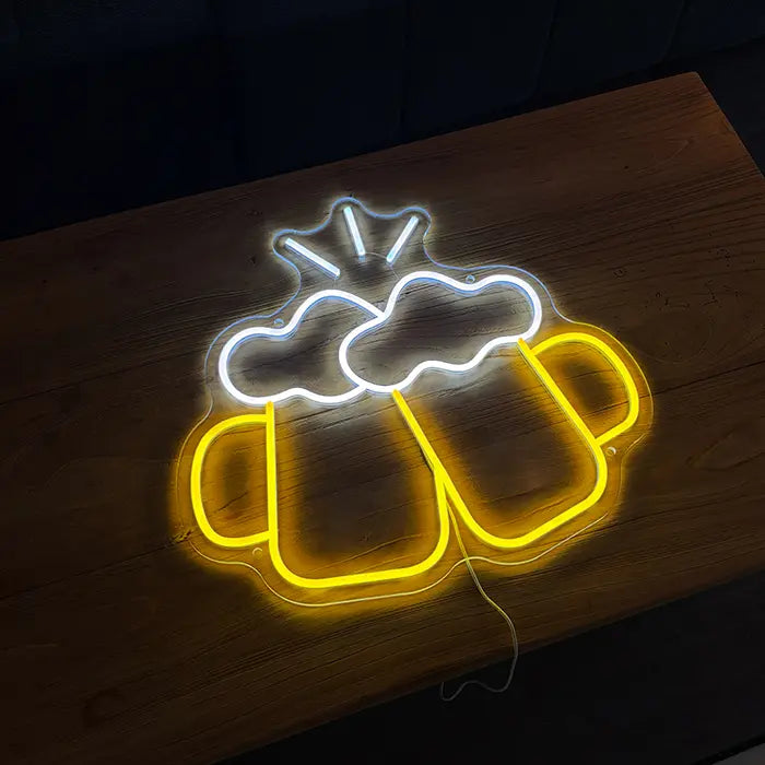 Beer Steins Neon LED Sign lying on a wooden table, yellow steins and white foam lines glowing