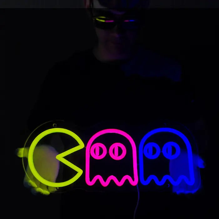 Retro Ghosts Neon LED Sign held in front of the body with both hands, yellow, pink and blue glowing