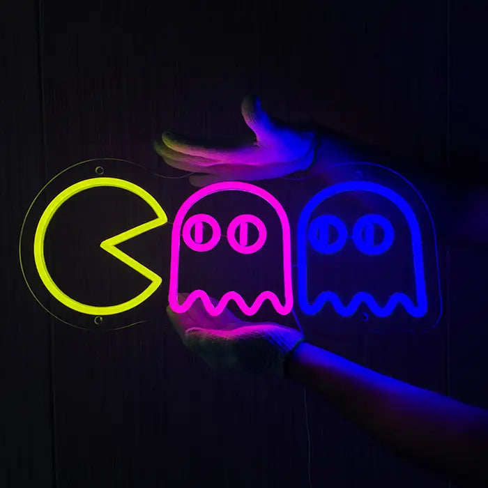 Retro Ghosts Neon LED Sign being held against a dark wooden wall with gloves