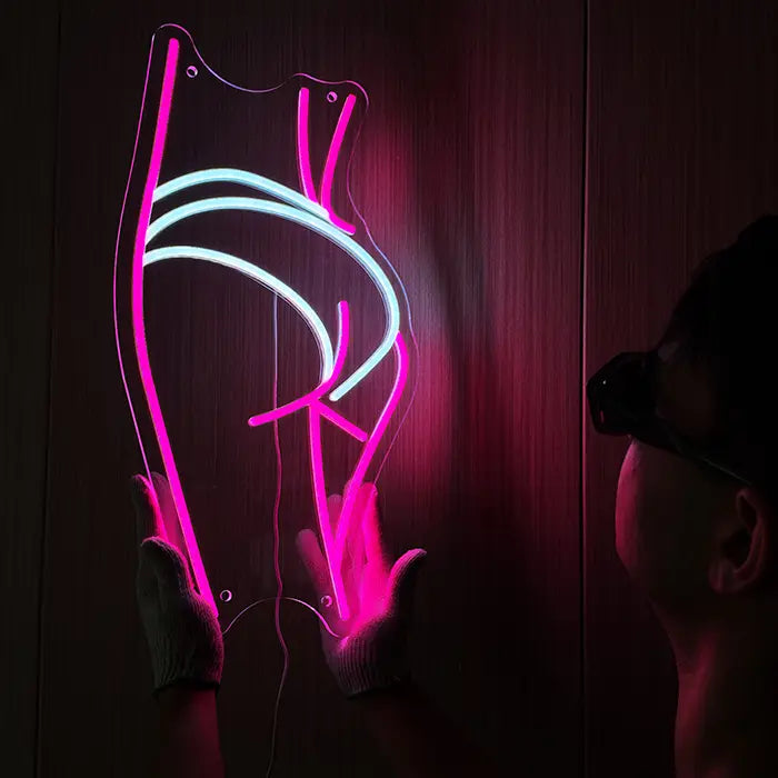 Sexy Boogie Neon LED Sign being lined up on the wall, a person holds it at the side