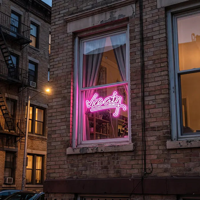 Vice City Original Neon LED Sign in the window of a brick house, seen from the street