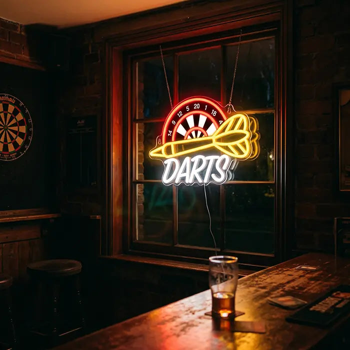 Darts Neon LED Sign with UV Print in a pub window, a table with a pint in front, a dartboard on the wall
