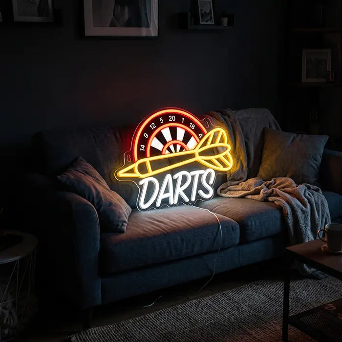 Darts Neon LED Sign with UV Print set up on a grey sofa with cushions and a throw