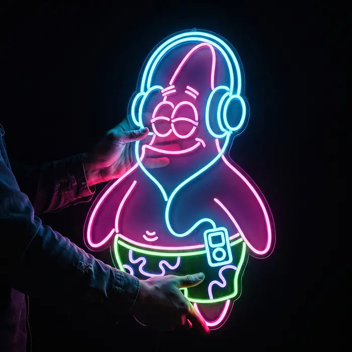 Patrick Kopfhörer Neon LED Schild wird von zwei Händen vor schwarzem Hintergrund gehalten, Größenvergleich