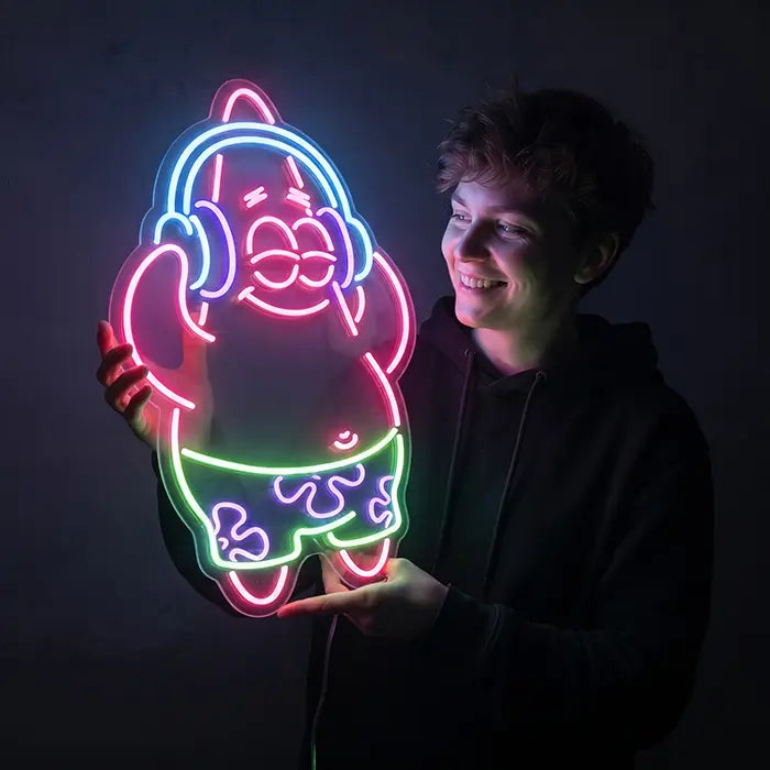 Patrick Musik Neon LED Schild wird von einer lächelnden jungen Person vor dunklem Hintergrund gehalten