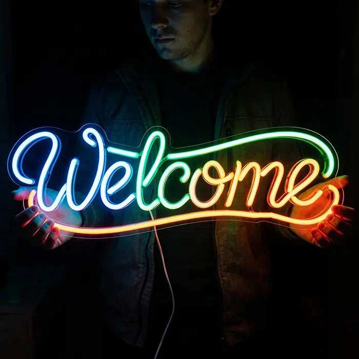 Welcome Neon LED Sign held in front of the body by a man