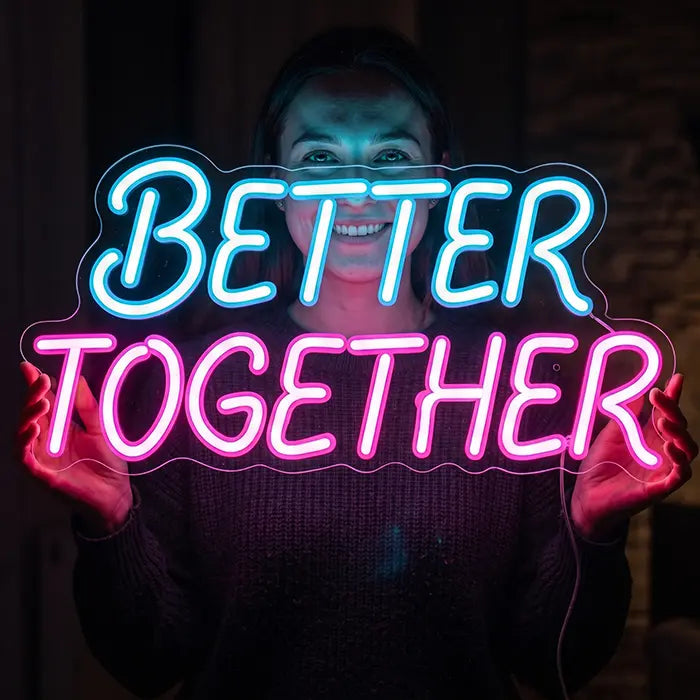 Better Together Neon LED Sign in blue-pink held by a smiling woman