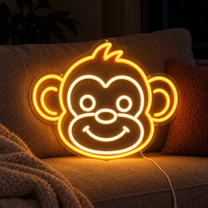 Monkey Face Neon LED Sign on a cosy sofa between cushions and a throw