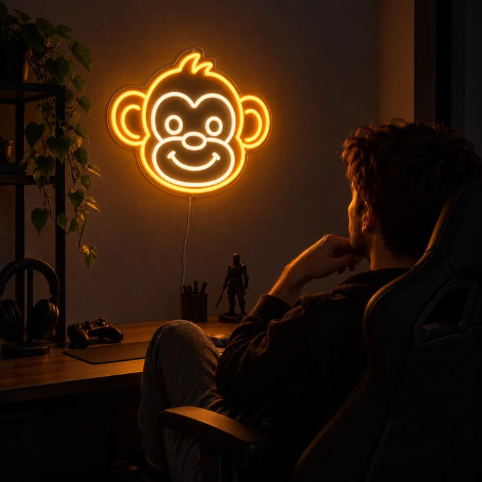 Monkey Face Neon LED Sign above a gaming desk, a gamer in a gaming chair in front of it
