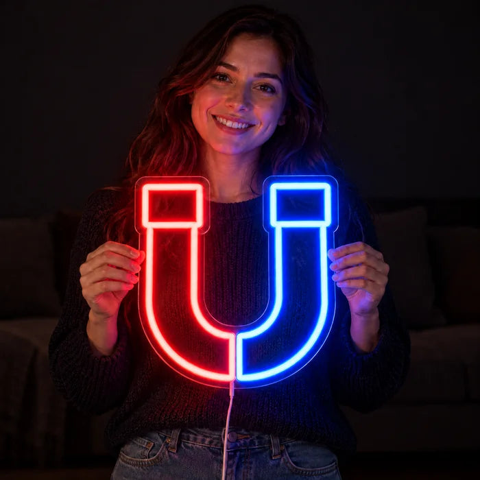 Magnetic Attraction Neon LED Sign held by a smiling woman against a dark background