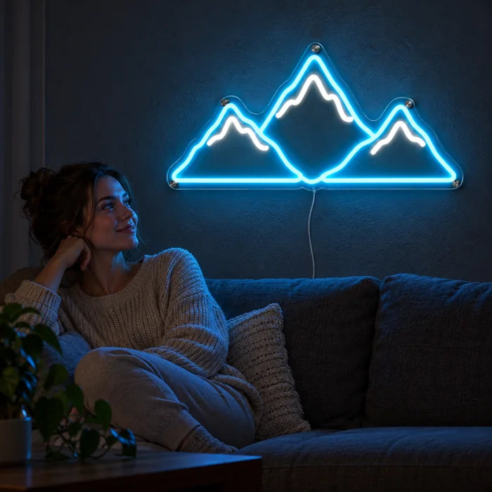 Mountain Silhouette Neon LED Sign on a living room wall, a person relaxing on the sofa in front of it