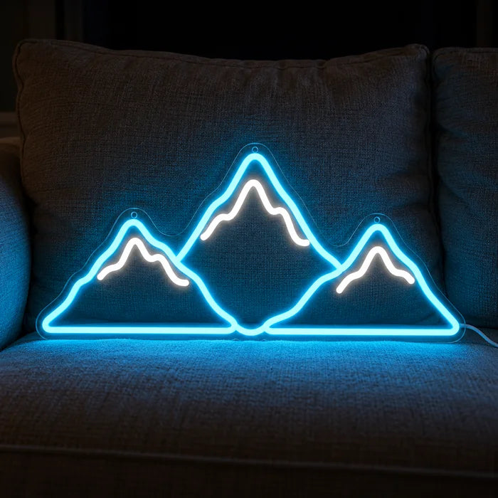 Mountain Silhouette Neon LED Sign on a cosy sofa between cushions and a throw