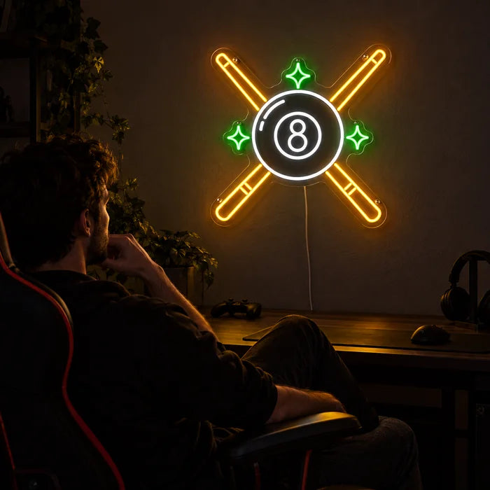 Crossed Pool Cues Neon LED Sign above a gaming desk, a gamer in a gaming chair in front of it