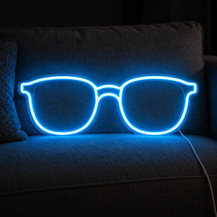 Blue Glasses Neon LED Sign on a cosy sofa between cushions and a throw