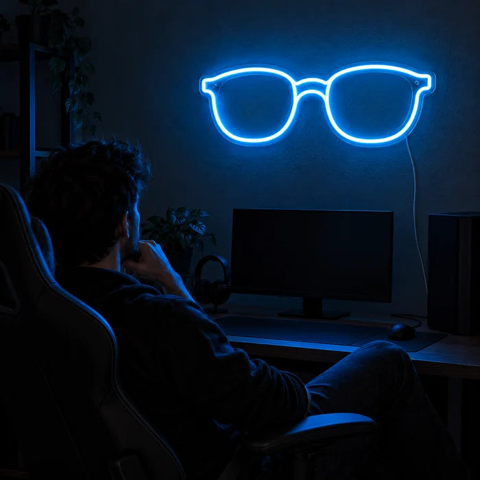Blue Glasses Neon LED Sign above a gaming desk, a gamer in a gaming chair in front of it