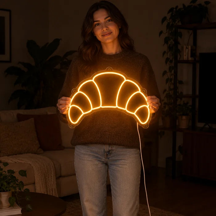 Butter Croissant Neon LED Sign held by a woman, showing its size compared to her body