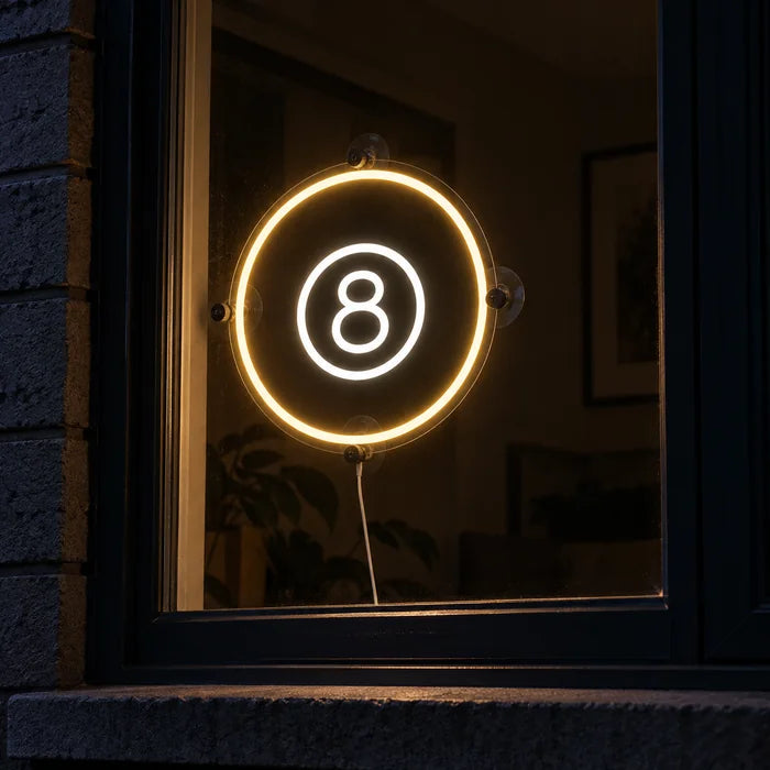 Black Eight Ball Neon LED Sign in a window, seen from the street at night