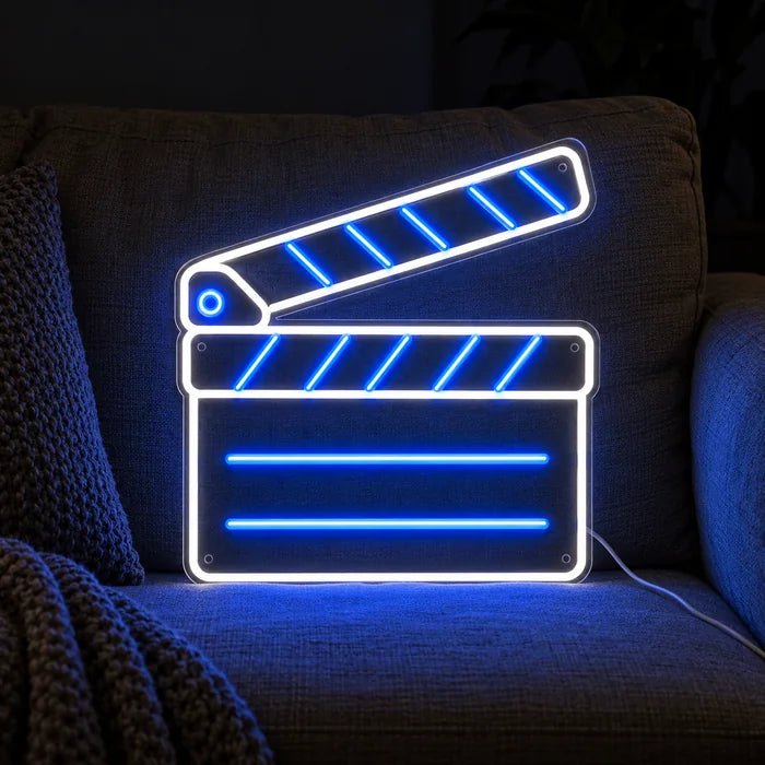 Klaket neon LED tabela, yastıklar ve battaniye arasında rahat bir kanepede