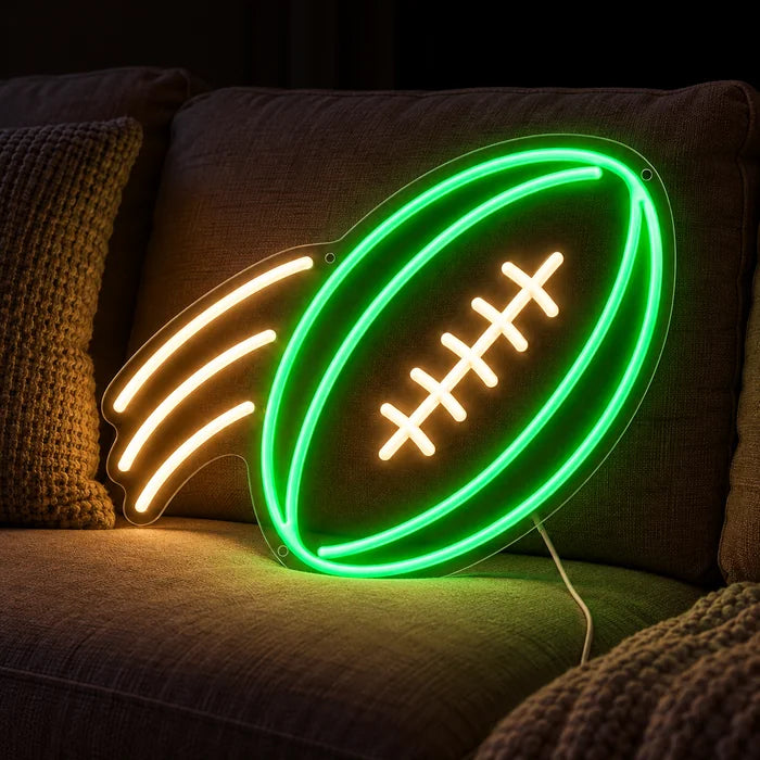 Flyvende football neon LED skilt på en hyggelig sofa mellem puder og tæppe