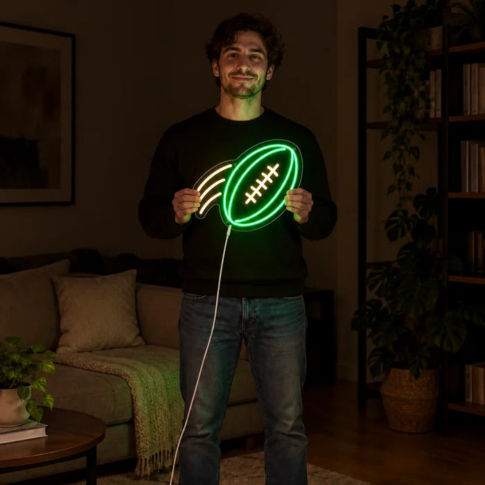 Flyvende football neon LED skilt holdt af en kvinde, viser størrelsen i forhold til kroppen
