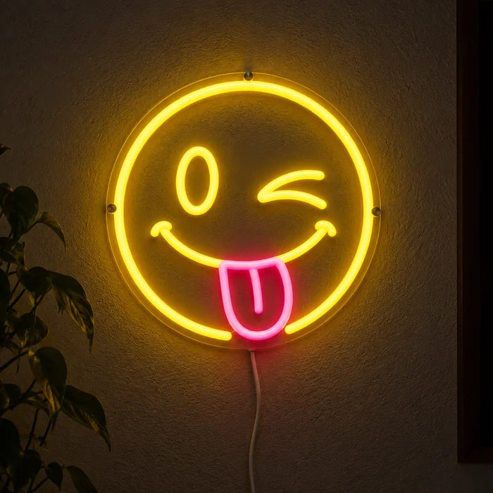 Cheeky Smiley Neon LED Sign glowing on a dark wall, close-up with connection cable