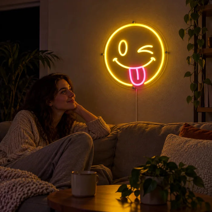 Cheeky Smiley Neon LED Sign on a living room wall, a person relaxing on the sofa in front of it