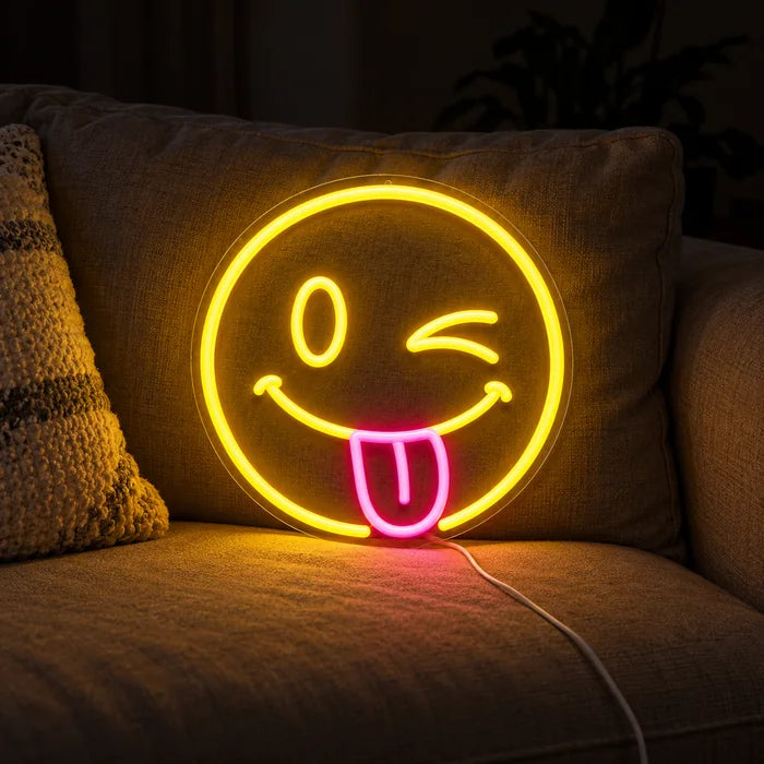Cheeky Smiley Neon LED Sign on a cosy sofa between cushions and a throw