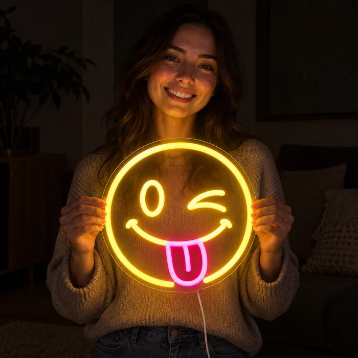 Cheeky Smiley Neon LED Sign held by a smiling woman against a dark background