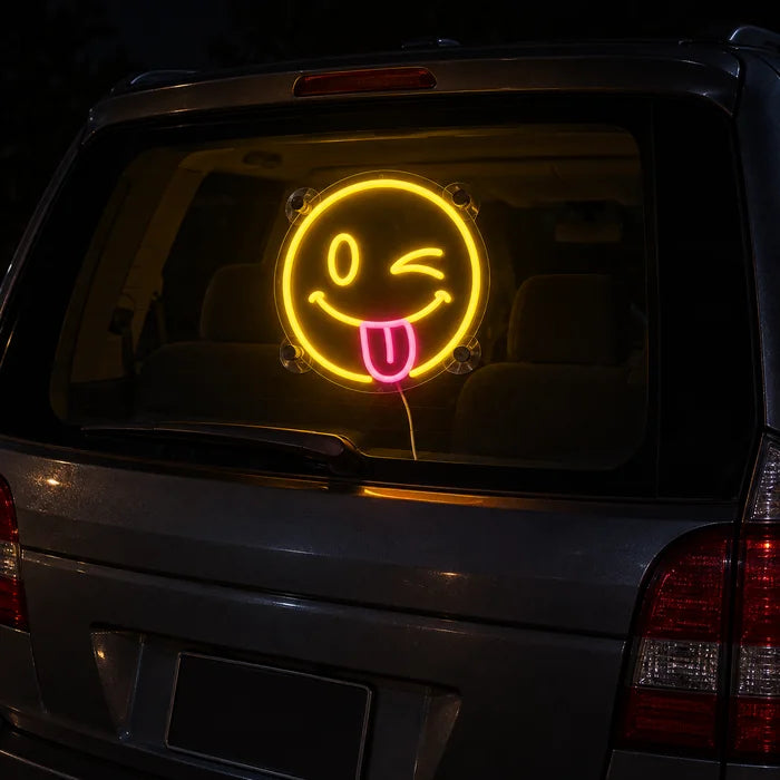 Cheeky Smiley Neon LED Sign on the rear window of a car at night