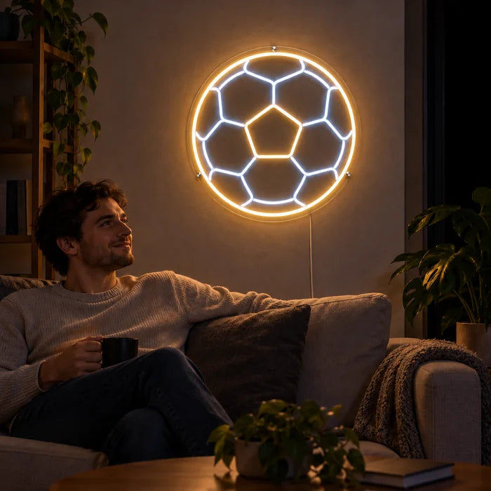 Football Neon LED Sign on a living room wall, a person relaxing on the sofa in front of it